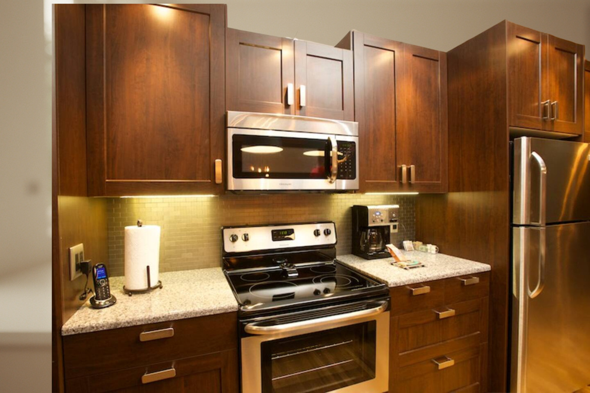 Kitchen area features a microwave/vent over electric range and full-size refrigerator - Ooma phone for local calls is next to the paper towels