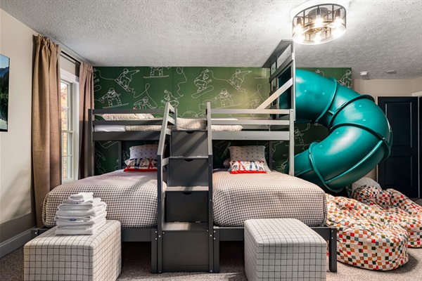 Sleep, play, repeat — stacked bunks, a twisty slide, and bean bags for instant fun