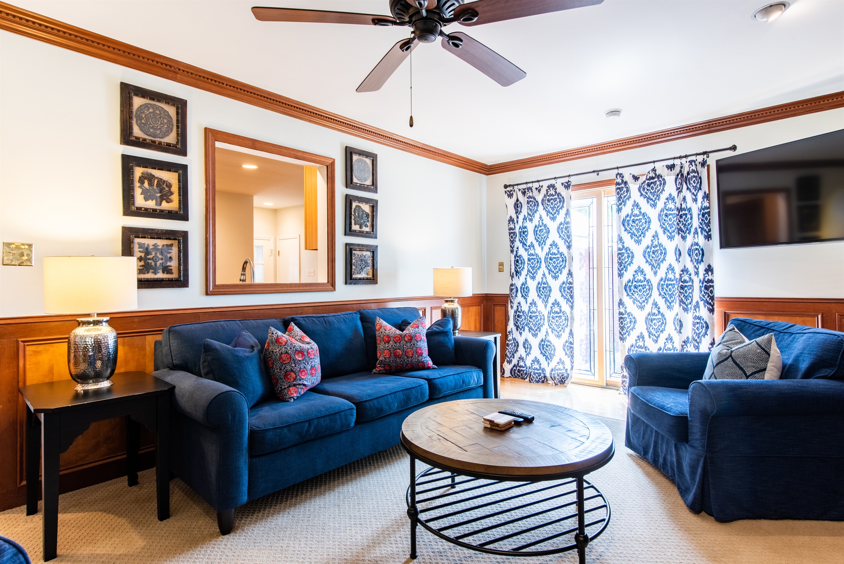 Cozy up in this elegant Louisville living room on the Kentucky Bourbon Trail. Enjoy cozy chairs, a wooden coffee table, built-in bookshelves, and a large TV—perfect for relaxing!