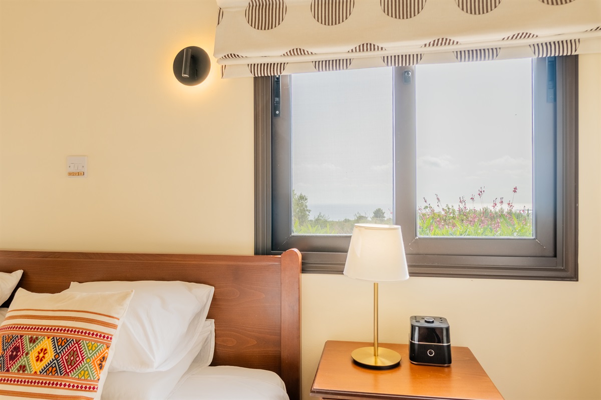 Master king ensuite bedroom with sea views and terrace access. King size bed, ceiling fan, dedicated AC/heating unit, vanity, large built-in wardrobes, bluetooth speaker/alarm clock.
