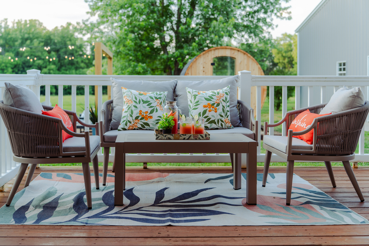 Enjoy fresh air and good company from this comfortable covered porch seating area.