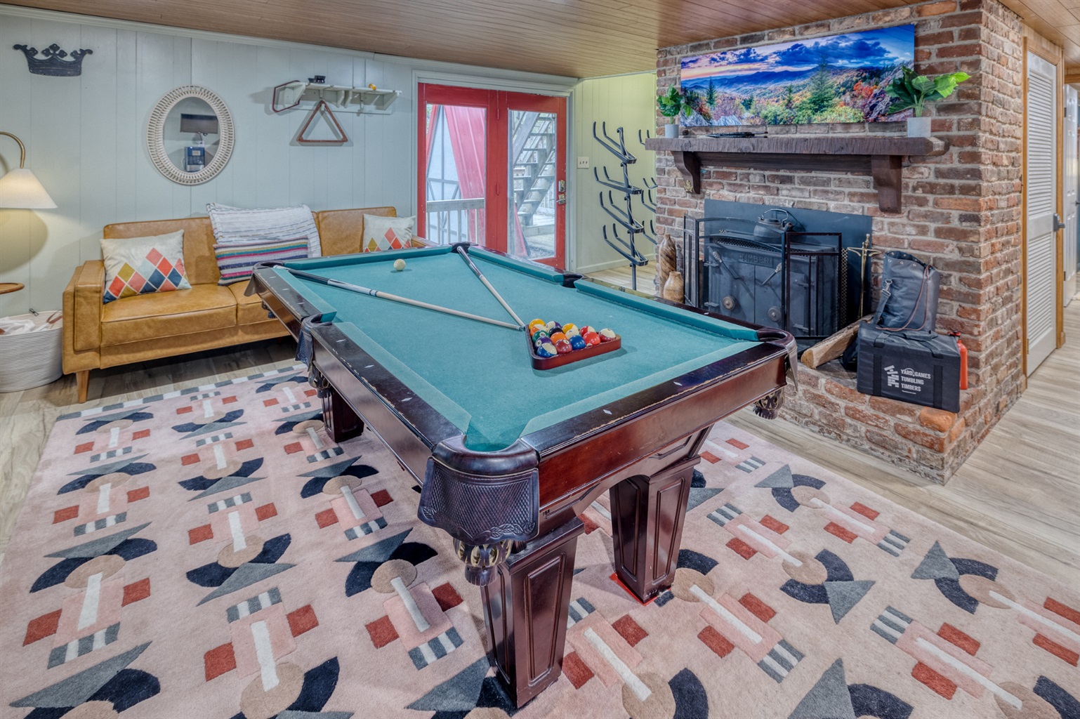 Featuring a classic pool table, cozy seating, and a brick fireplace, this basement is perfect for hosting a game night and relaxing after a busy day.