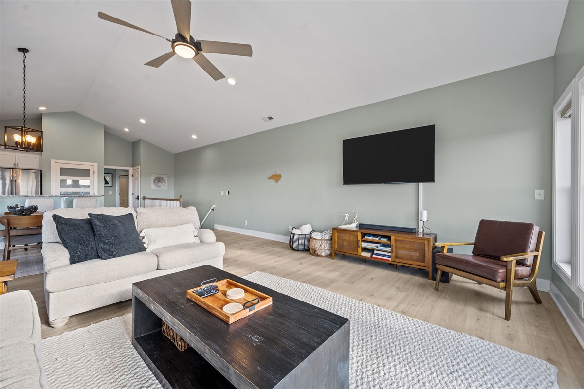 Living room with a big-screen TV and plenty of comfy seating, perfect for movie nights or chilling after a day at the beach
