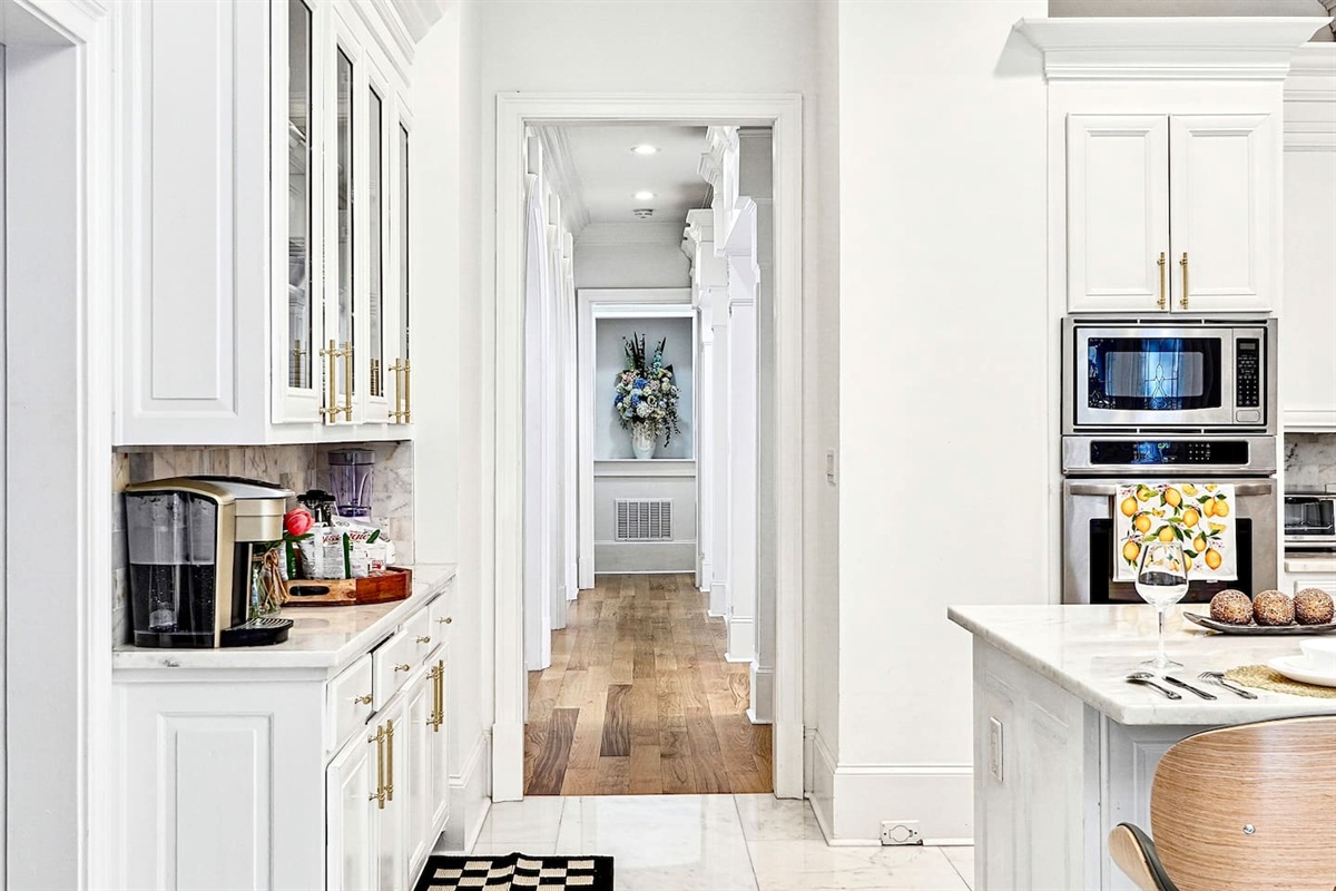 Bright and beautifully designed kitchen with white marble counters and white wood cabinetry. Fully equipped and ideal for cooking, gathering, and hosting with ease.