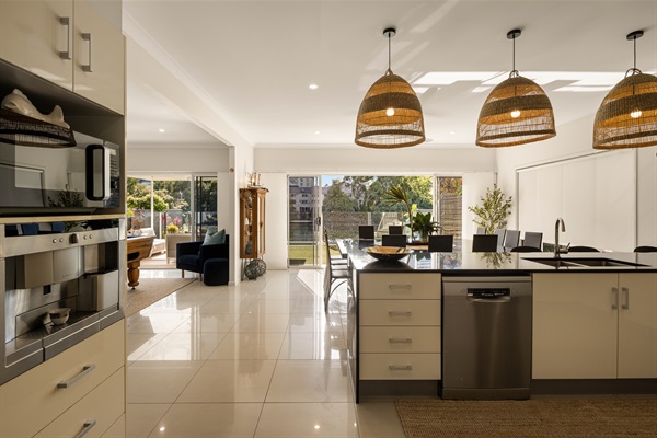 Seamless indoor flow between designer kitchen, dining and relaxed lounge spaces.