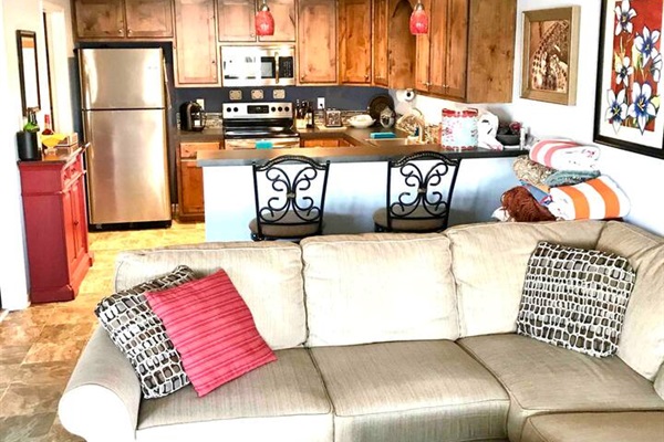 Open concept kitchen and living room with swivel bar height chairs for dining at the kitchen bar and swivel to look at the lake views. 