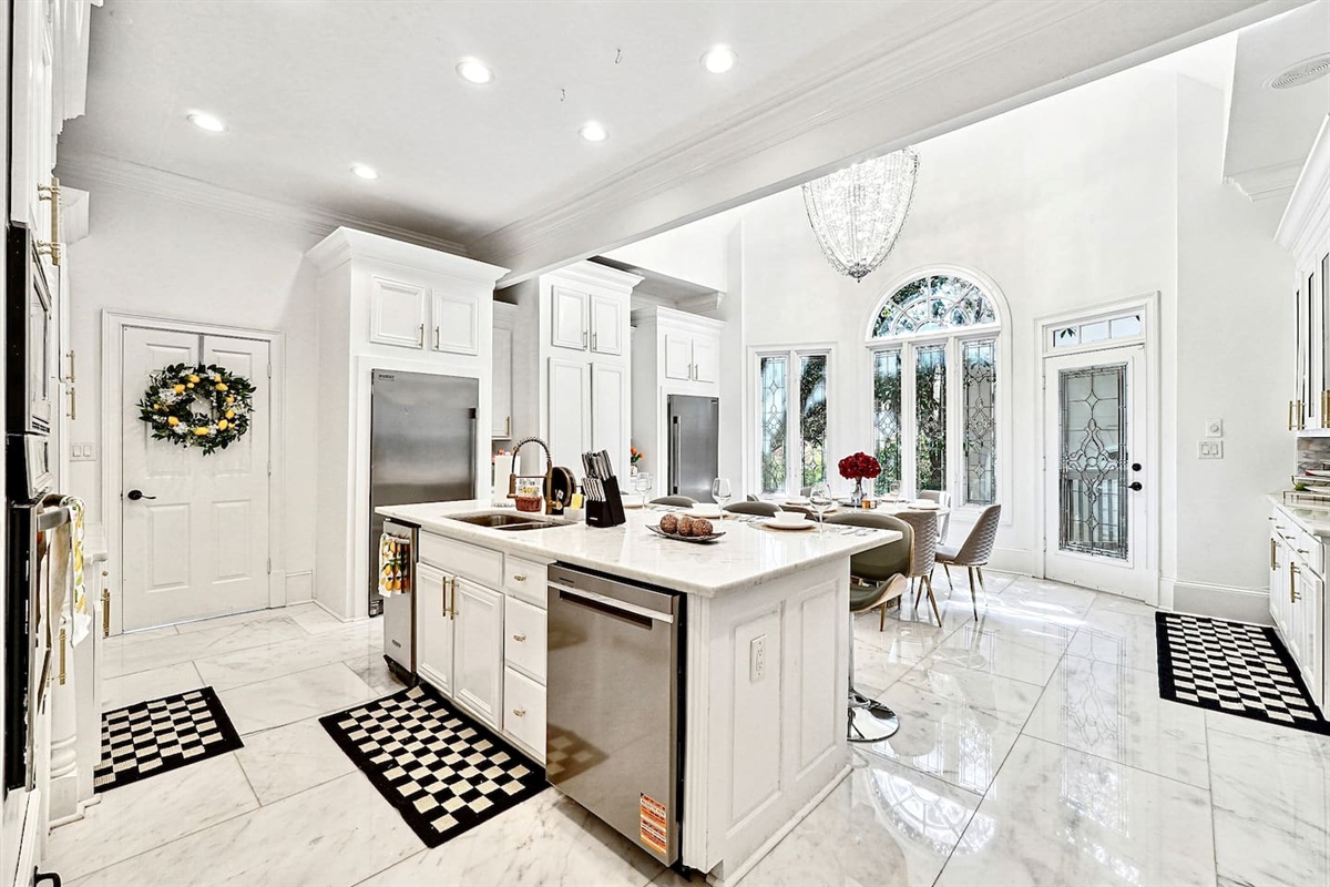 Bright and beautifully designed kitchen with white marble counters and white wood cabinetry. Fully equipped and ideal for cooking, gathering, and hosting with ease.