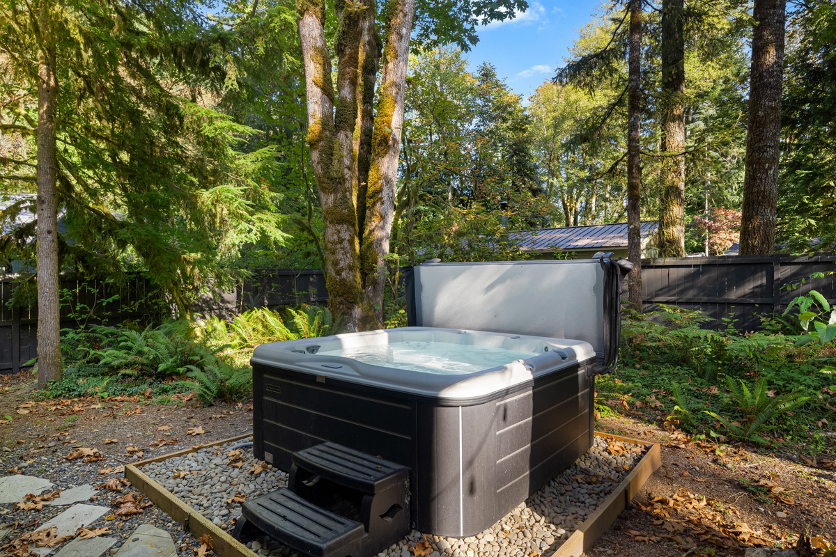 Soak it in — a private hot tub surrounded by ferns and fir trees.