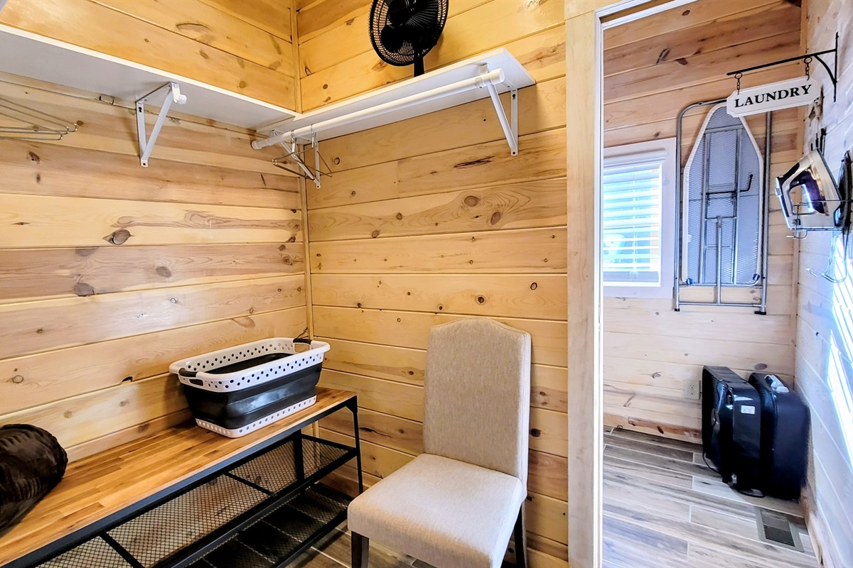 Open walk in closet and laundry room with ironing board