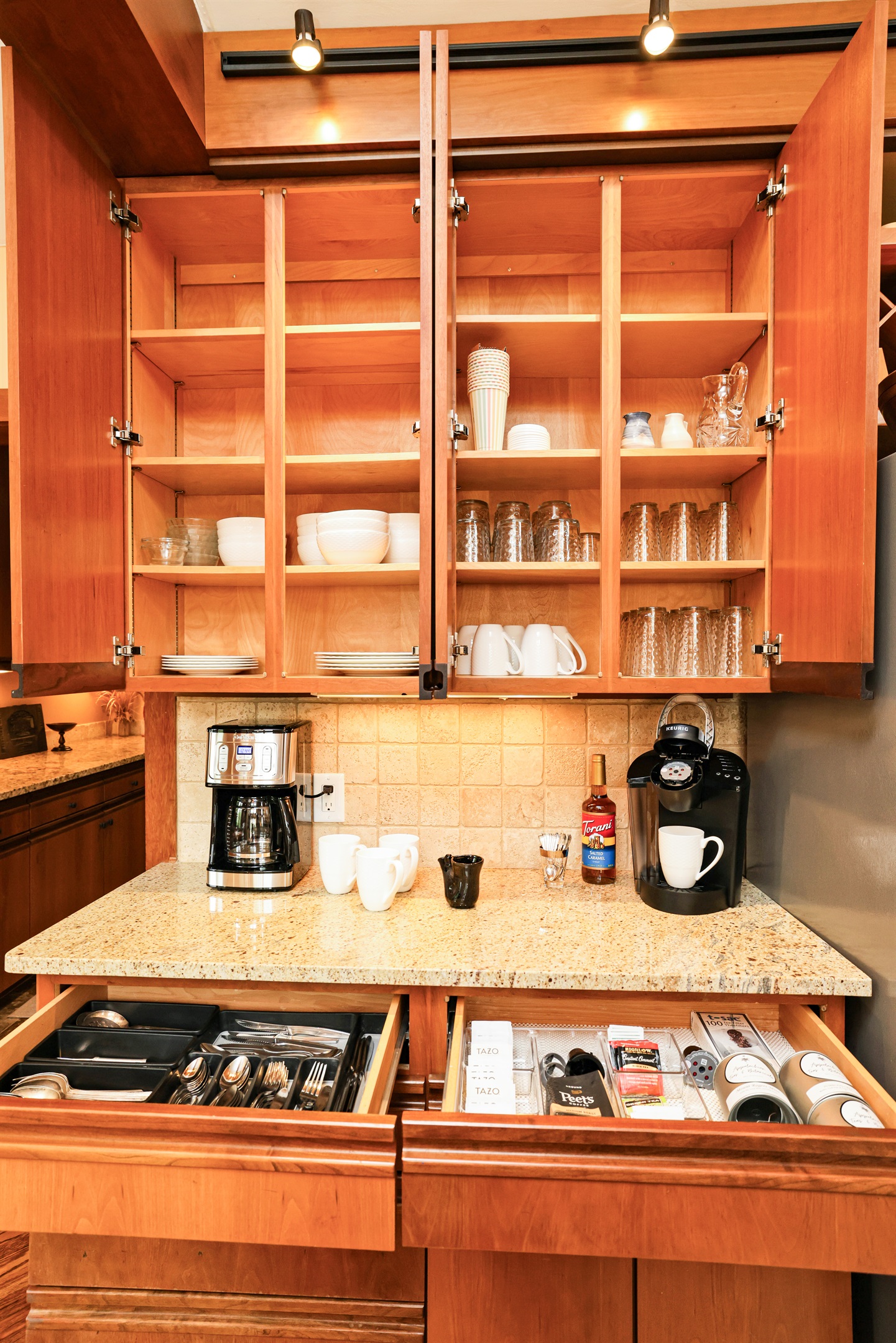 Coffee and tea bar area with a drawer of tea selections and sweeteners plus Peets Coffee to start out your stay!  Dishes are stored above with 16 place settings (they are set up on dining table when this photo was taken!)