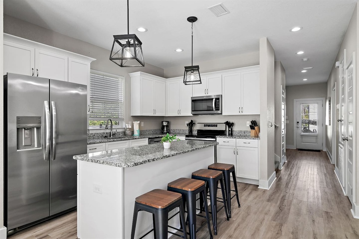 The kitchen is equipped with a large two-door refrigerator with ice maker, stove, oven, coffee-maker and dishwasher.

