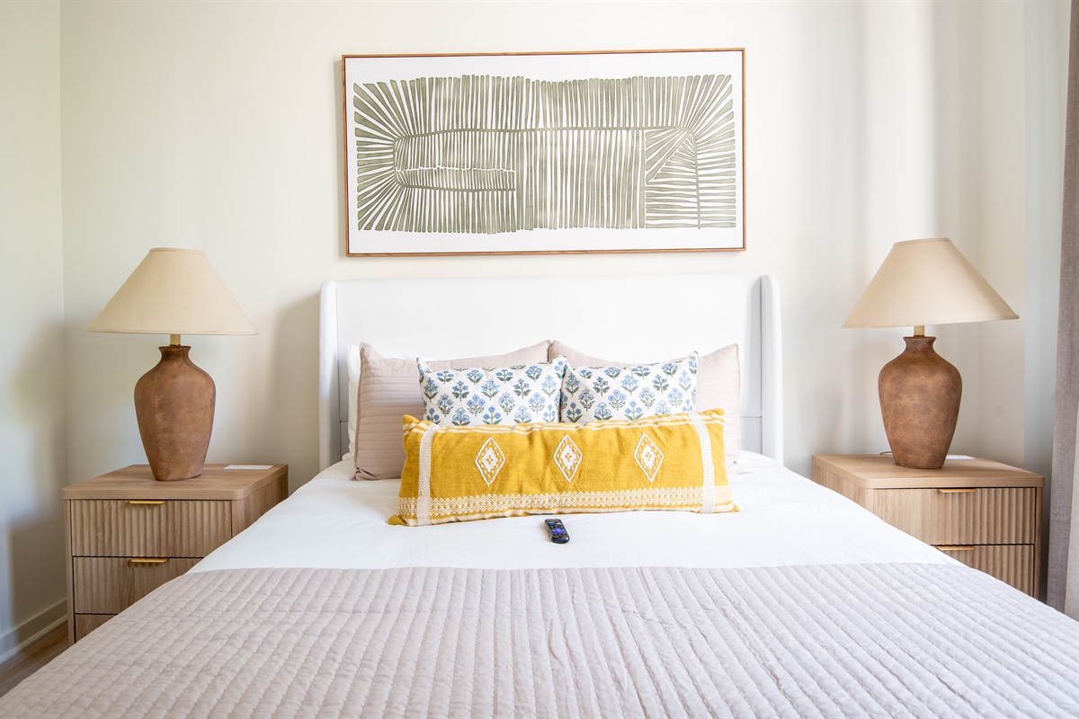 Serene bedroom with plush bedding, warm lighting, and stylish accent pillows