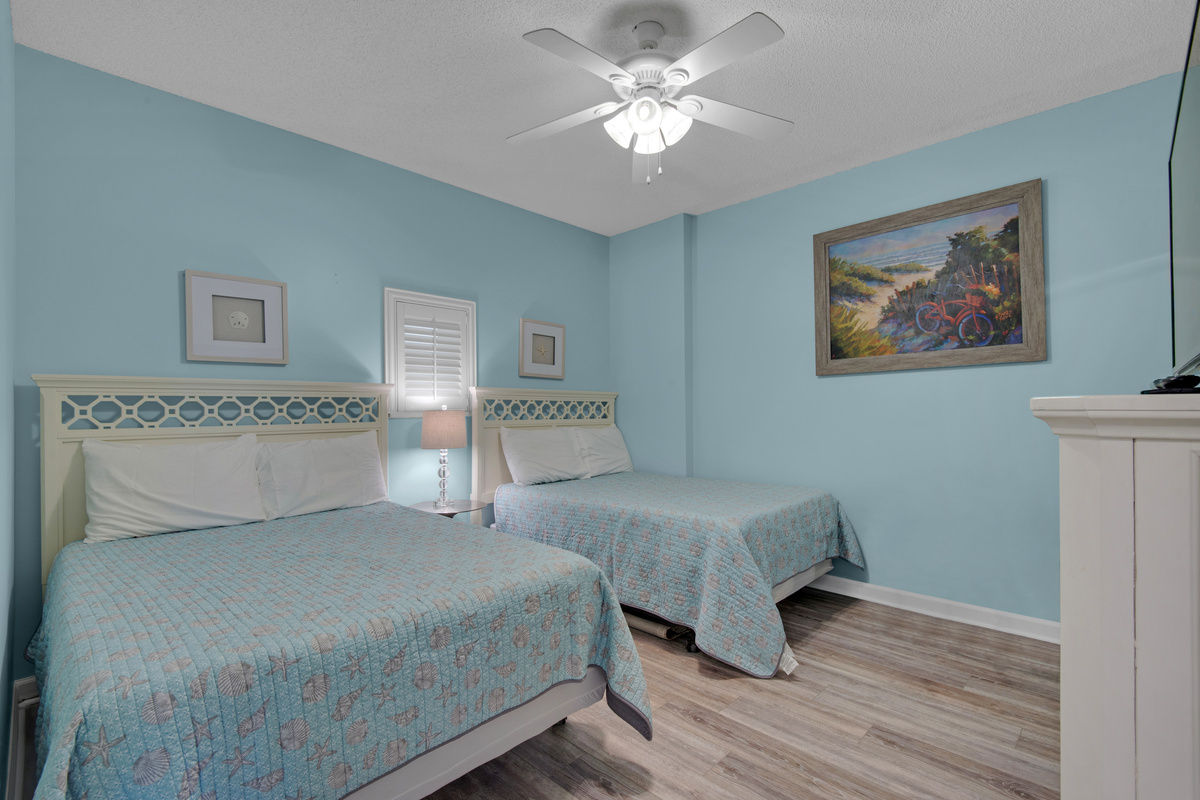 Second bedroom with two full beds and a TV.