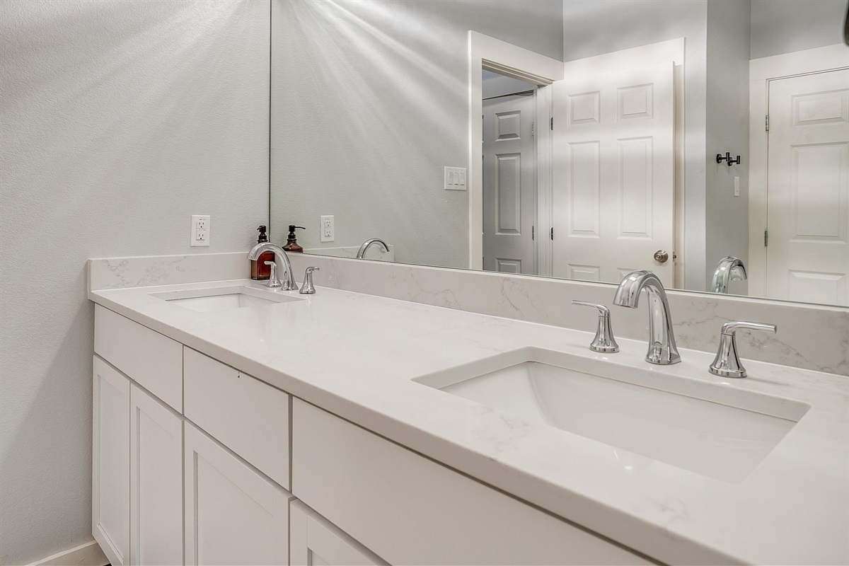 Double vanity bathroom with sleek modern finishes—stocked and spotless.