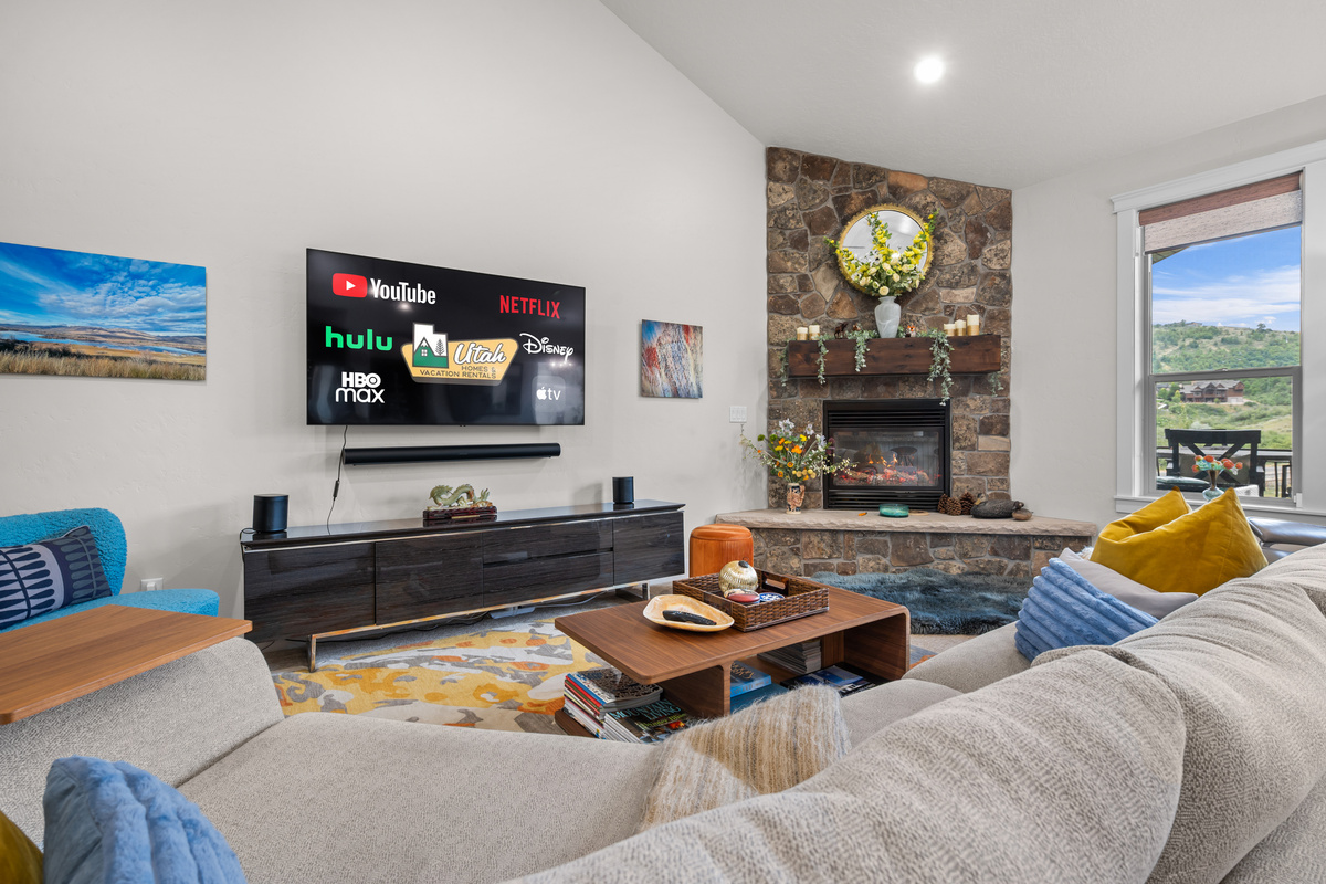 Spacious great room with soaring ceilings, cozy fireplace, and plenty of seating for gathering after a day of adventure.