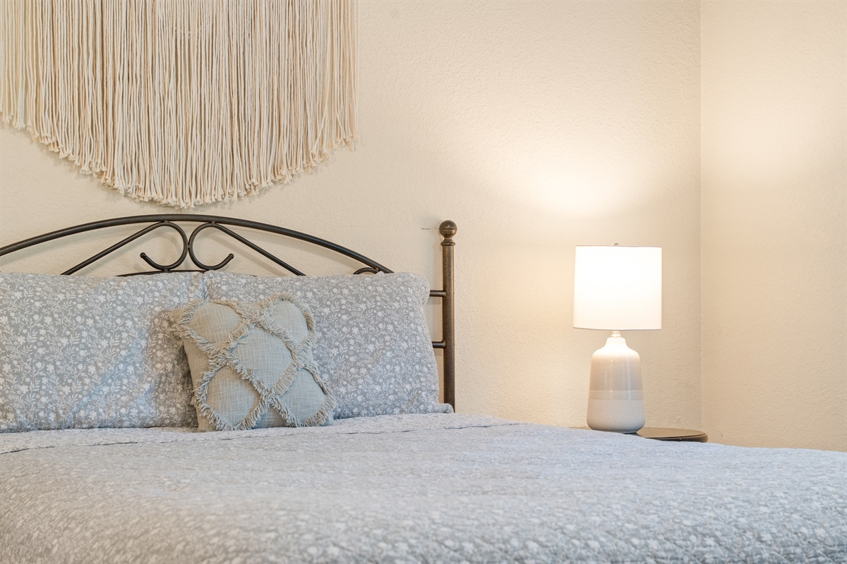 Close-up of the neatly styled queen bed reinforces the comfortable, restful feel of the bedroom.
