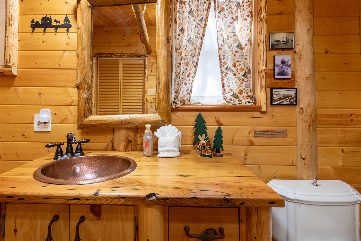 Half bath with a copper sink and rustic décor