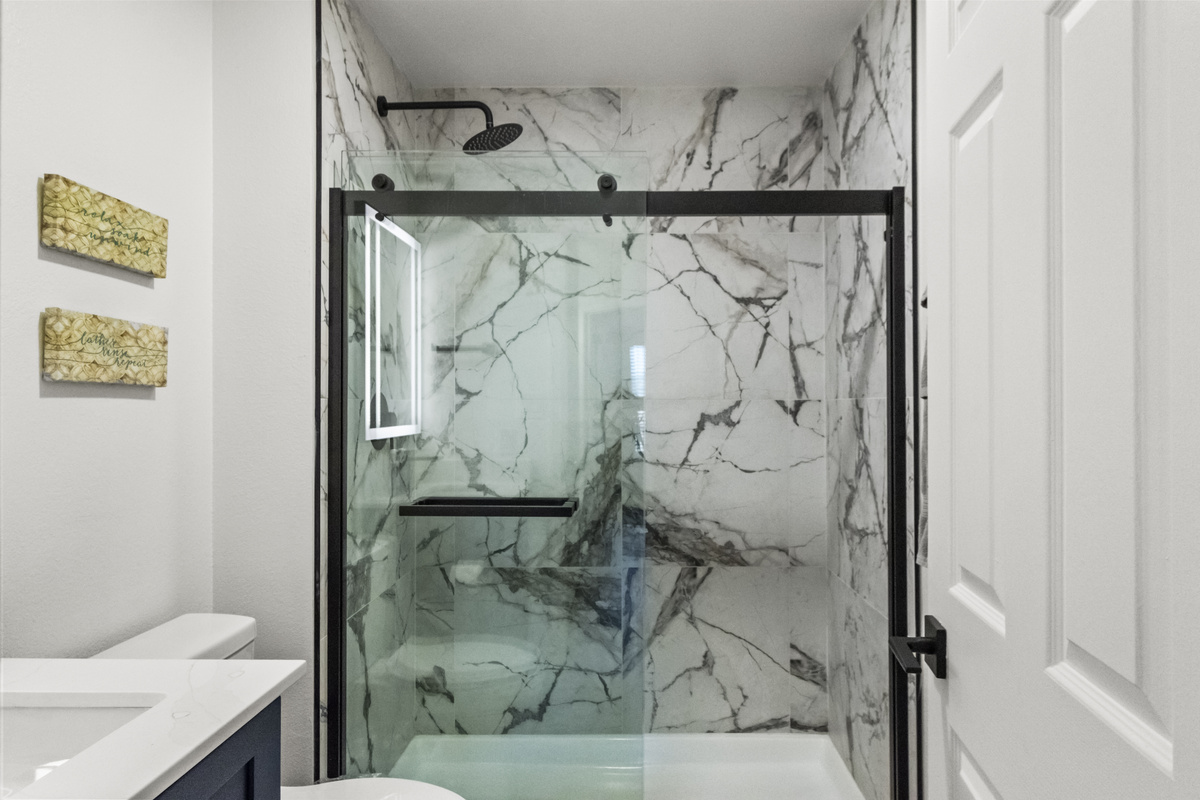 Clean and spacious bathroom with glass patition for the shower area. 