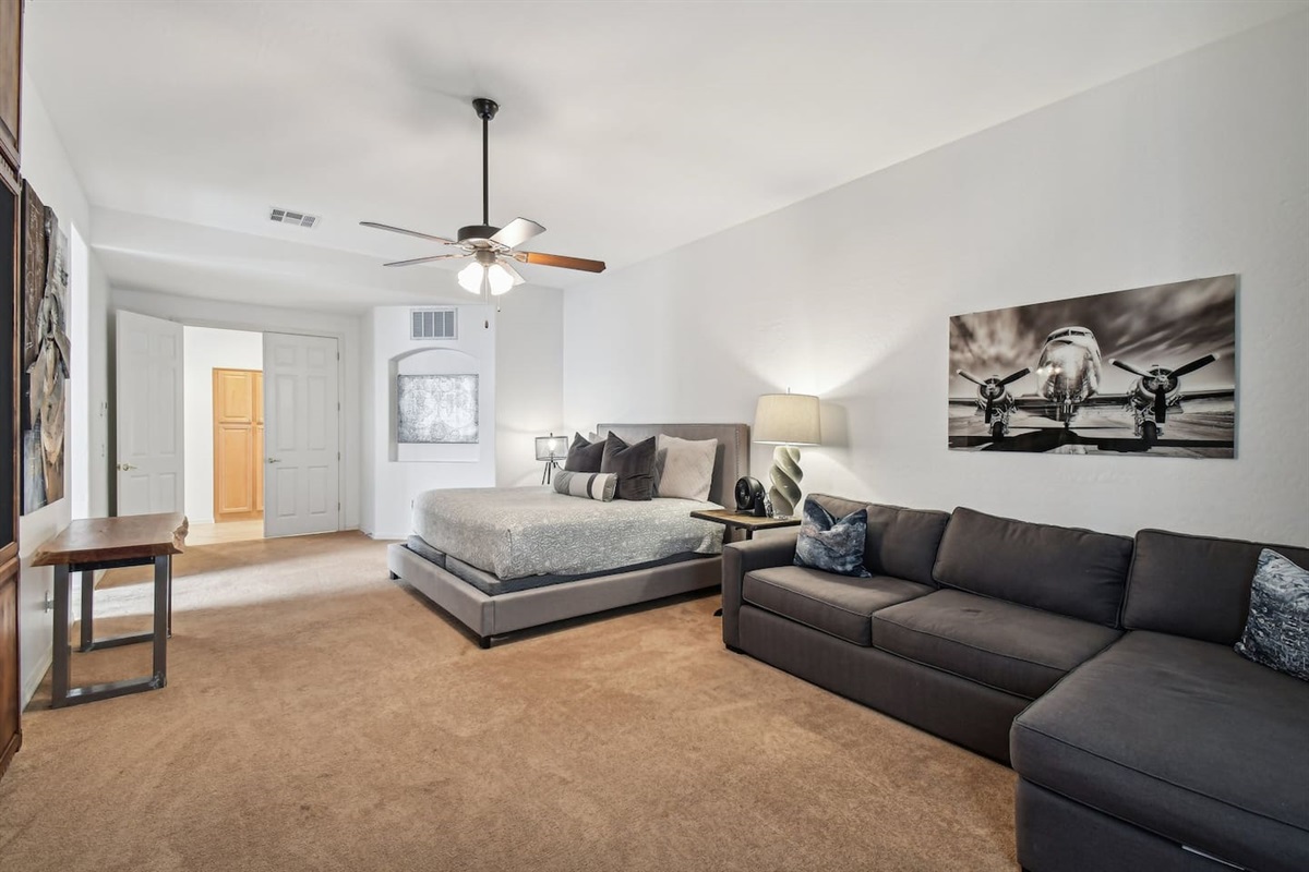 Unwind in the luxurious king suite featuring a plush bed, spacious layout, cozy lounge sofa, and aviation-inspired decor. Ideal for morning slow starts or movie nights in bed.