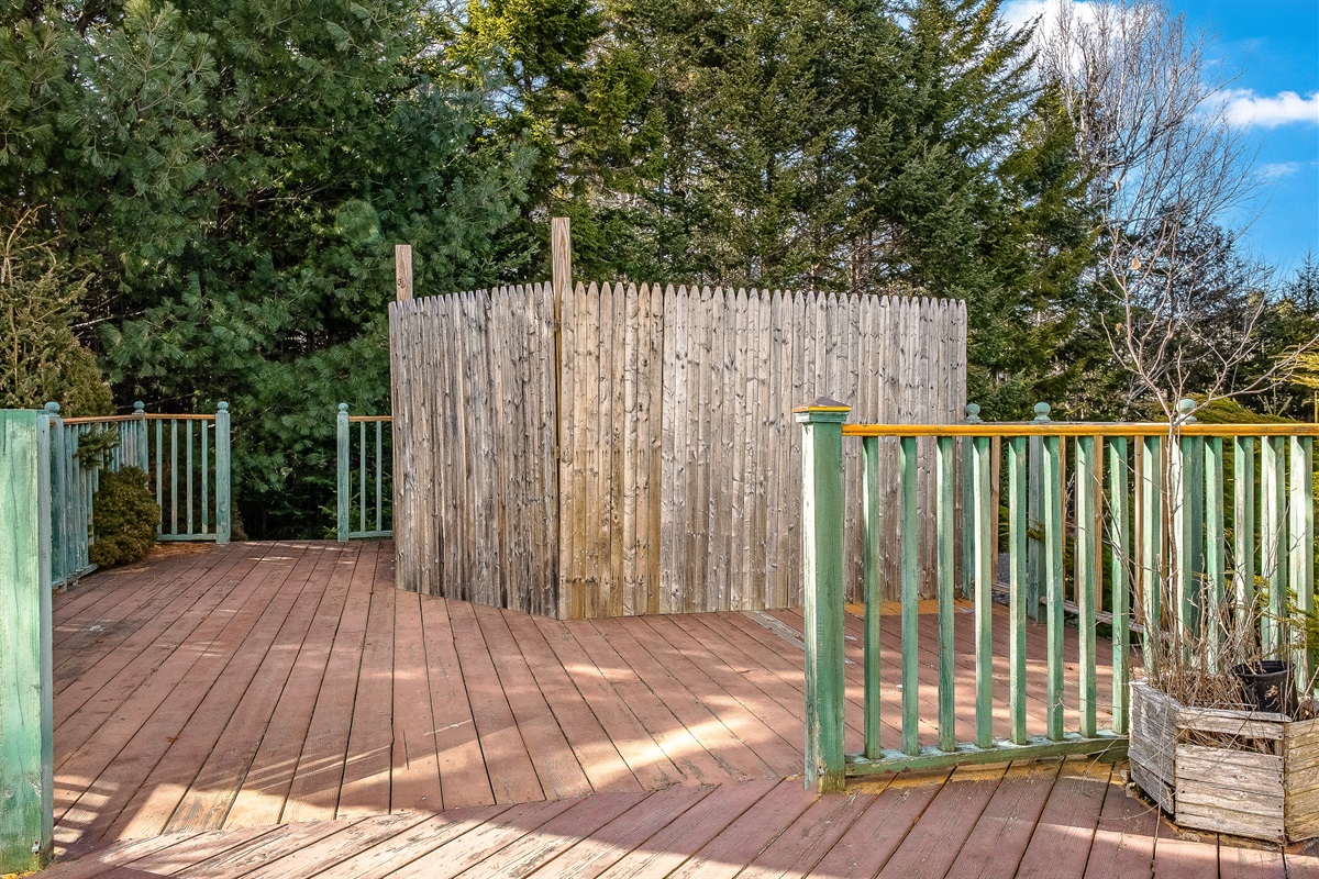 The expansive deck overlooks the fire pit area. The privacy fence is strategically placed to keep smoke away from the deck, ensuring a comfortable evening of roasting marshmallows and stargazing in the fresh air of Southwest Harbor.