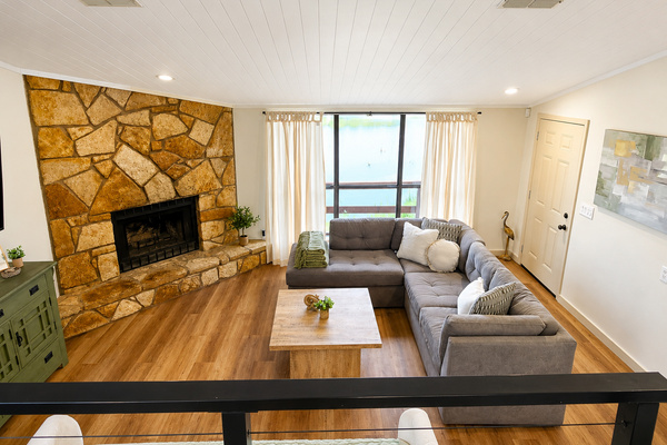 Open living room with fireplace and panoramic lake views.