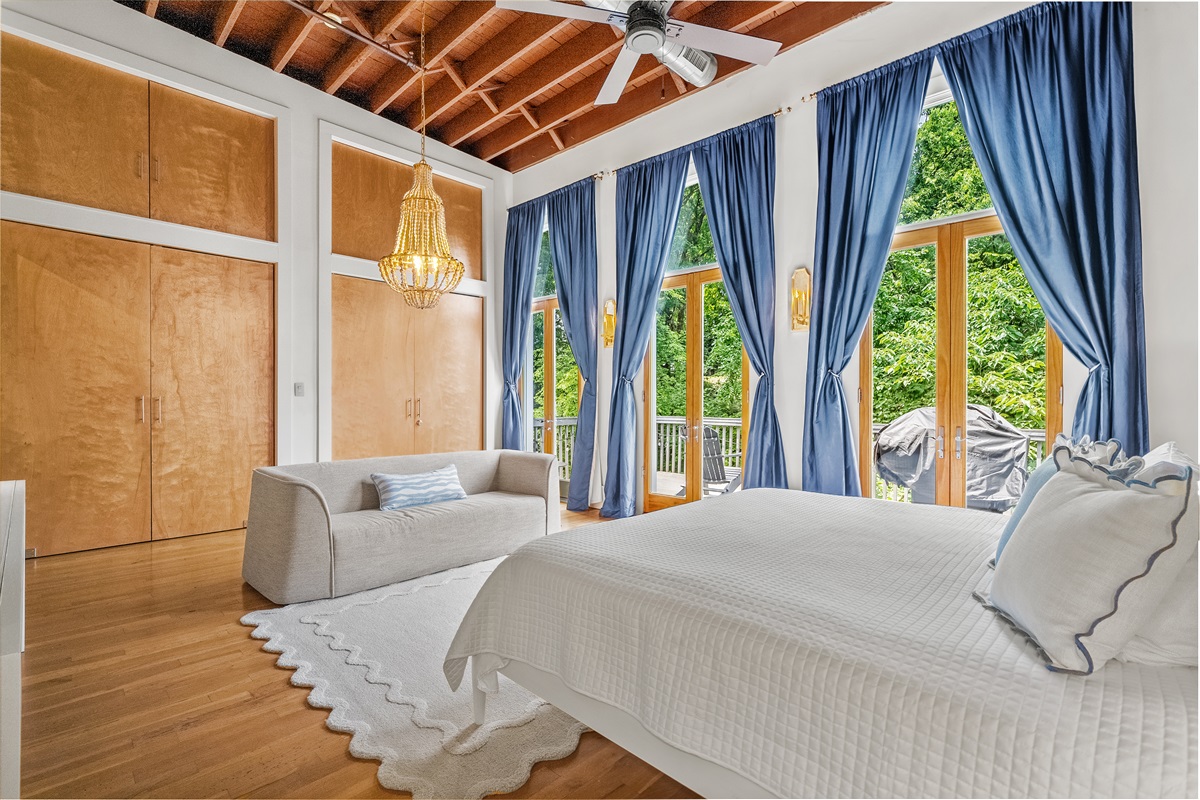 Master bedroom with king bed, private balcony, lounge seating, and ensuite bathroom.