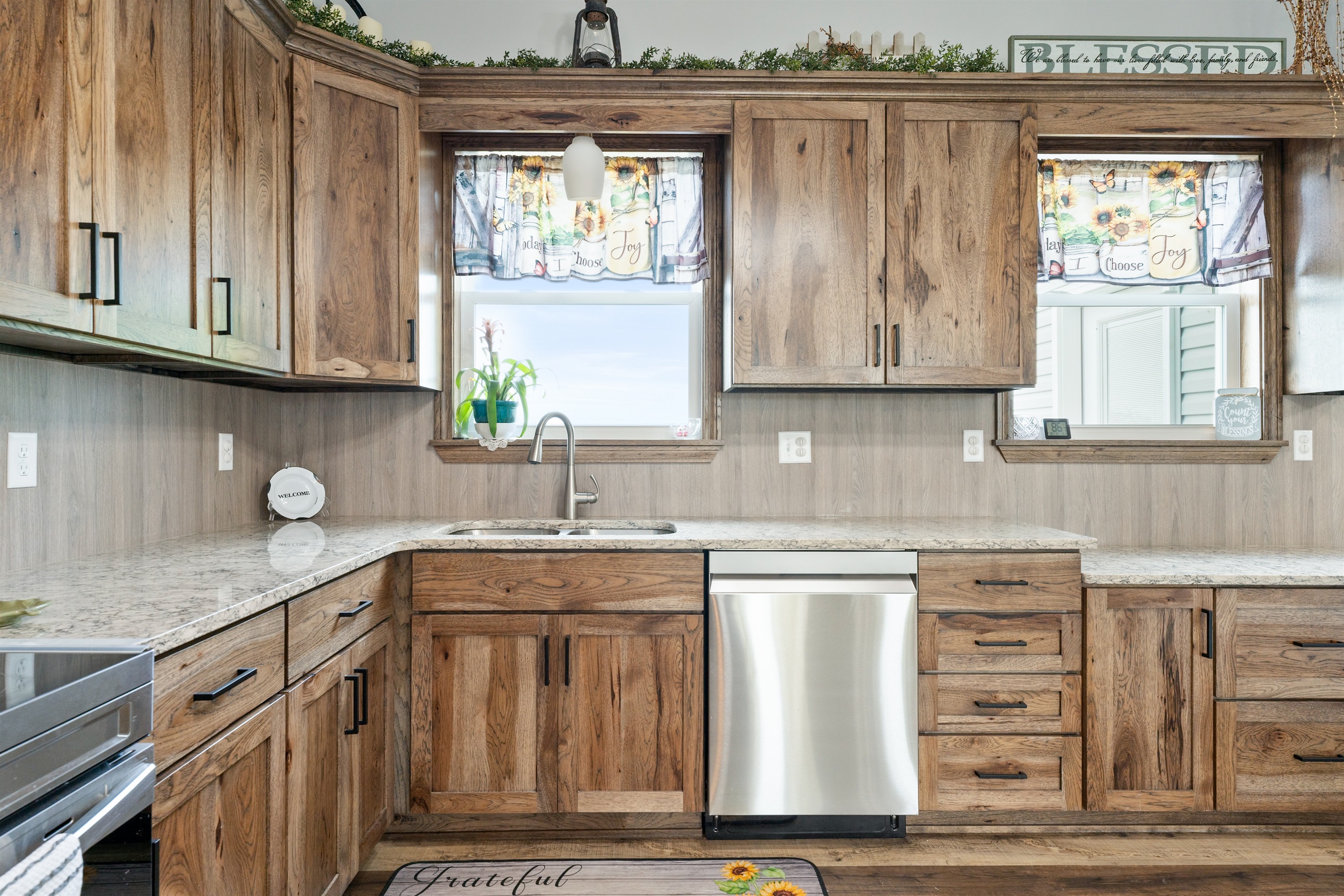 Beautiful farmhouse-style kitchen with warm wood cabinetry, granite counters, and a spacious island with bar seating for four.