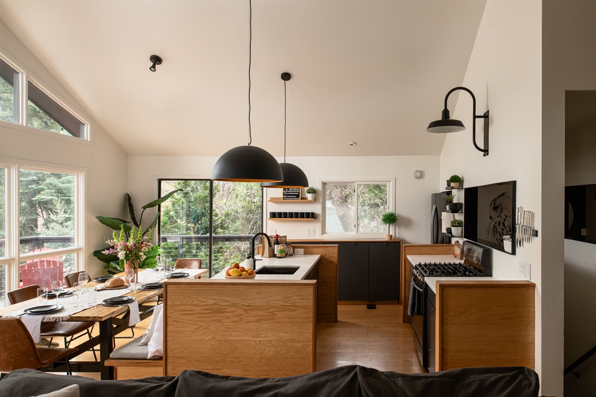 Bright, open kitchen and dining area with forest views—perfect for cooking, gathering, and enjoying meals together.