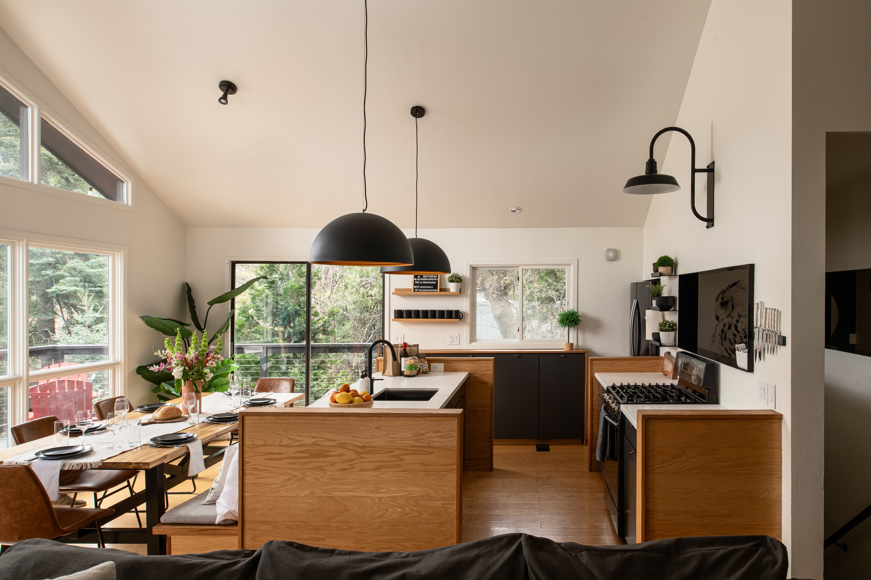 Bright, open kitchen and dining area with forest views—perfect for cooking, gathering, and enjoying meals together.
