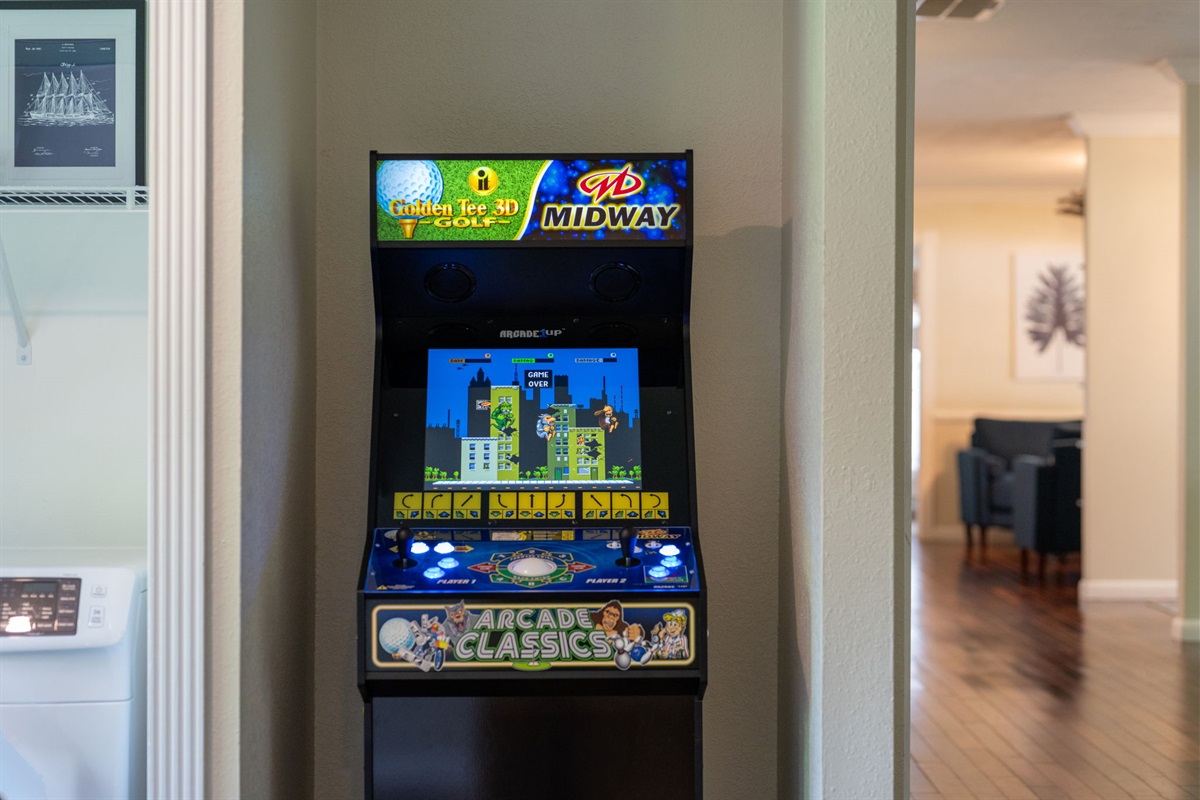 Multi-purpose space featuring a laundry station and a retro arcade game machine.
