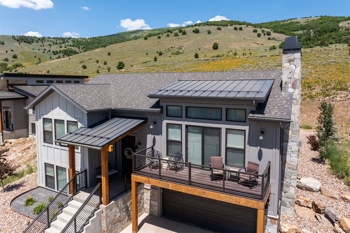 Aerial view of the home showcasing its modern mountain design and hillside setting
