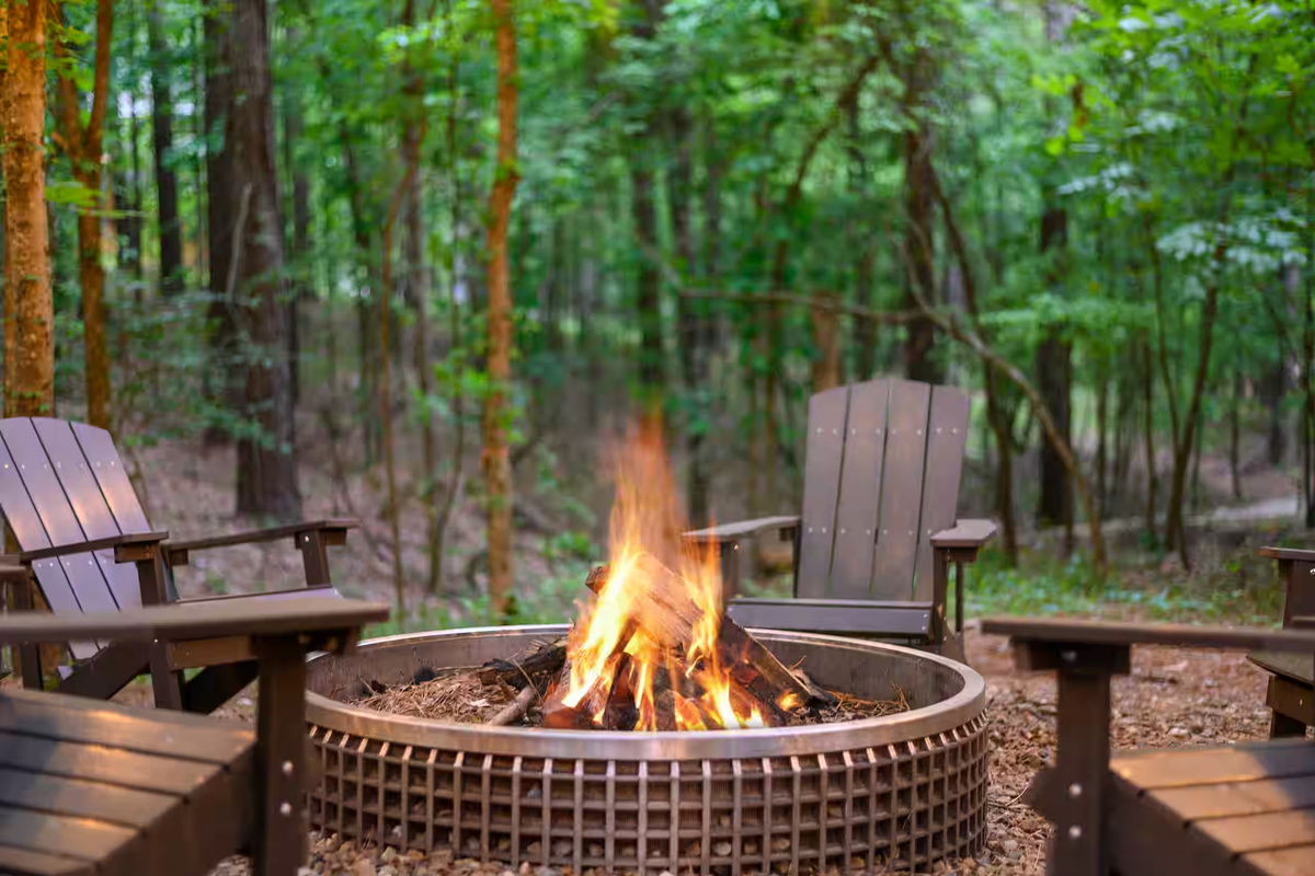 Fire Pit Oasis: Gather around for starlit stories and s'mores in this enchanting wooded retreat!