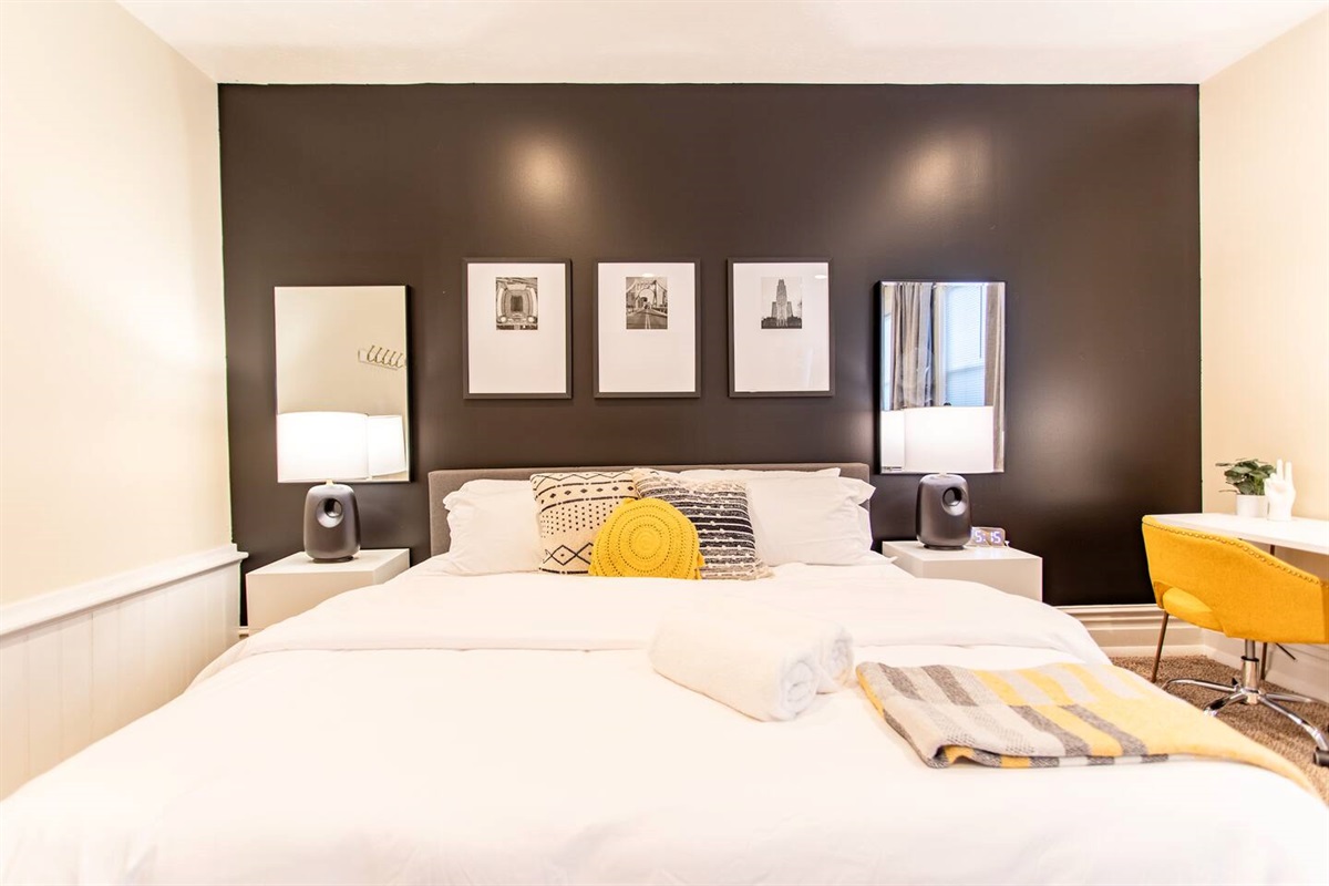 An elegant bedroom with refined décor, featuring a luxurious bed and a sleek, organized workspace tucked in the corner, creating a perfect balance of relaxation and productivity.