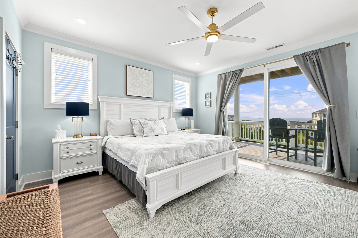 Relax in this spacious primary suite with plush bedding, bedside lighting, ample storage, and a large smart TV for your comfort and entertainment