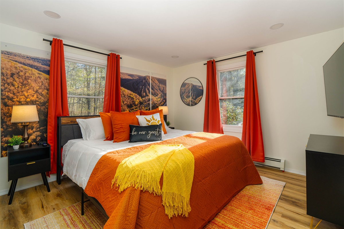 👑 The Denton Hill Sunset Room: a king bed under a mountain-sunset mural.