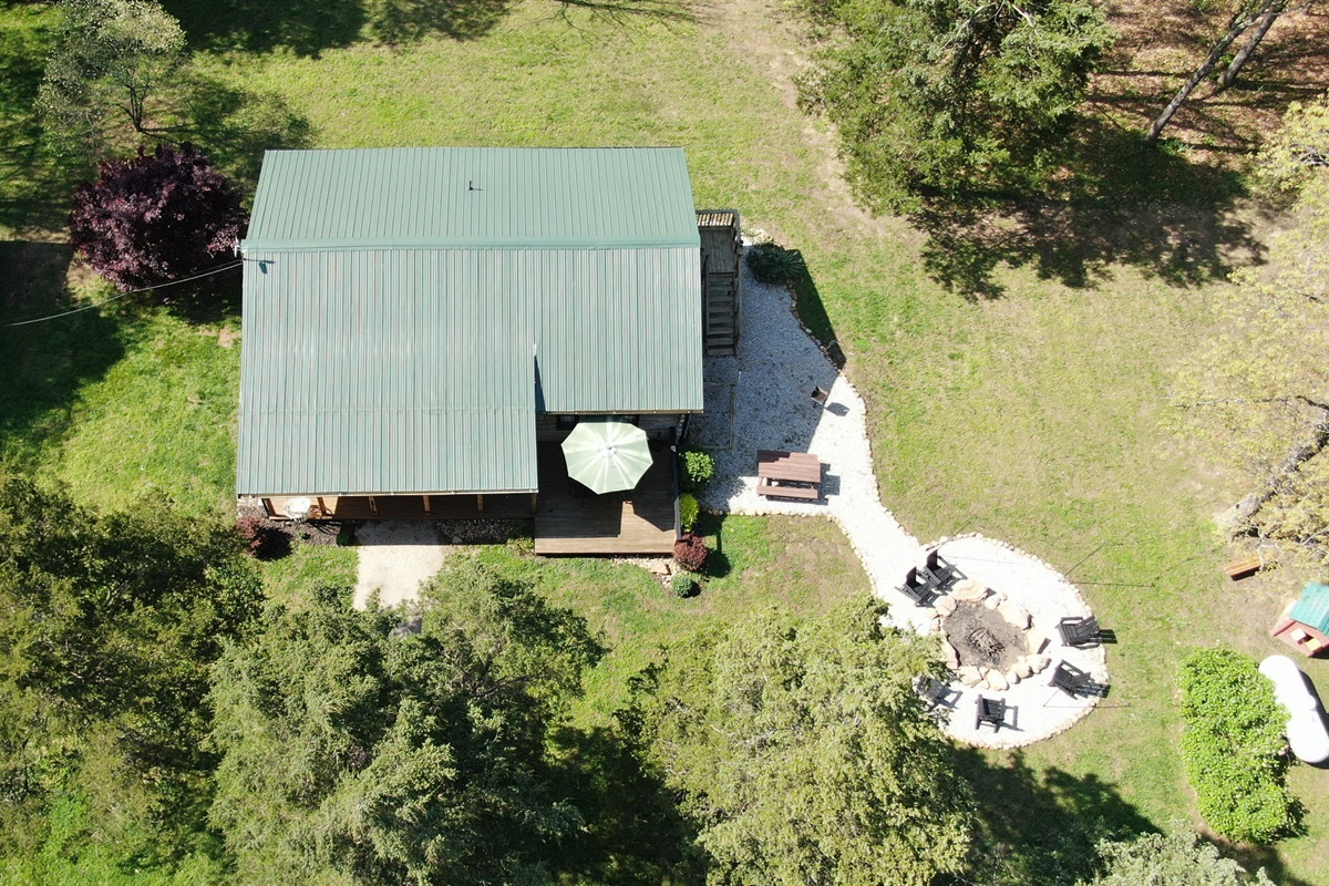 Enjoy the spacious yard for play and relaxation, with a cozy fire pit at the heart of your private 10-acre retreat.