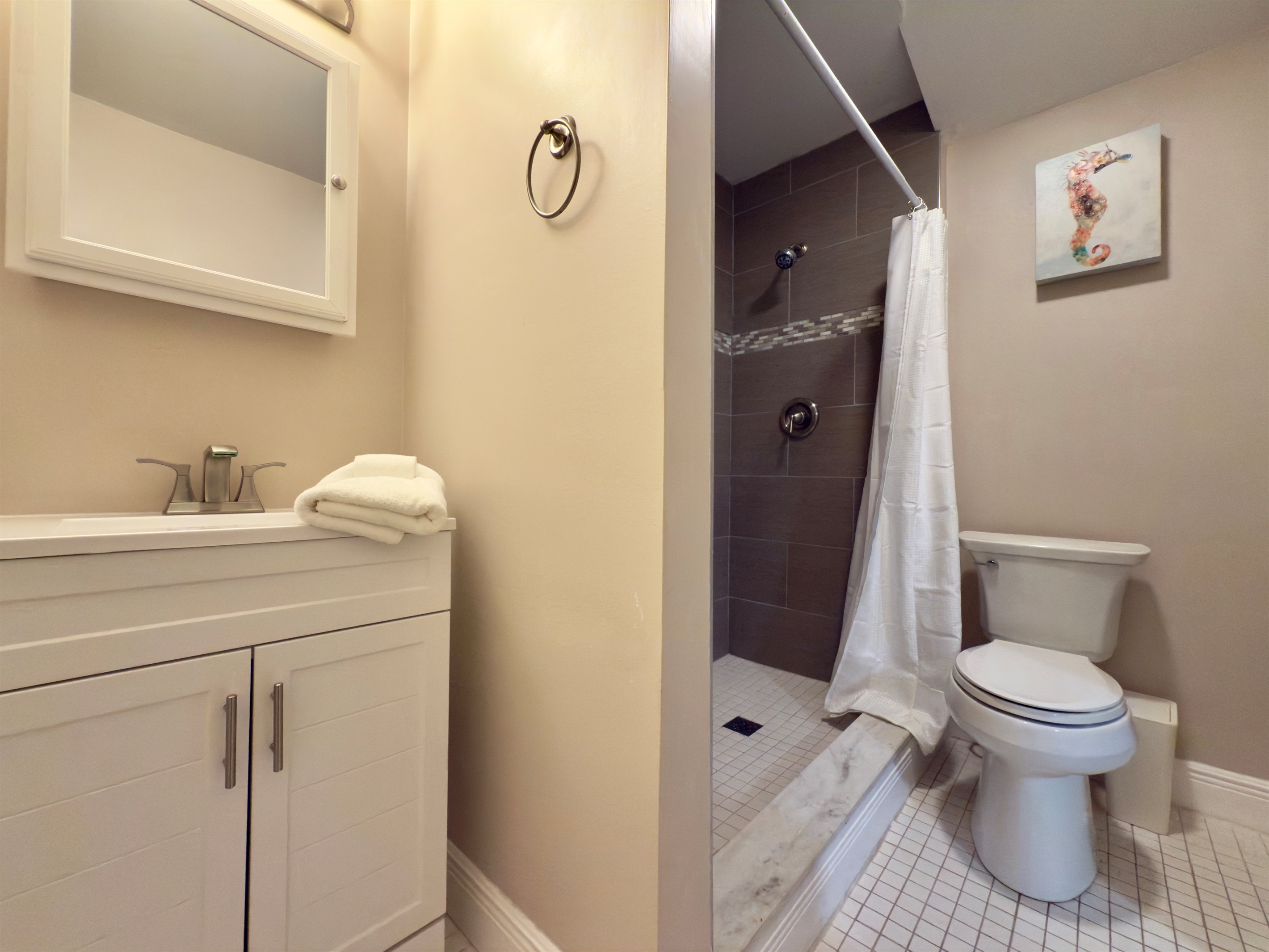 The standout feature is the generously sized walk-in shower, finished in rich natural stone tiles with a textured pebble-style floor.