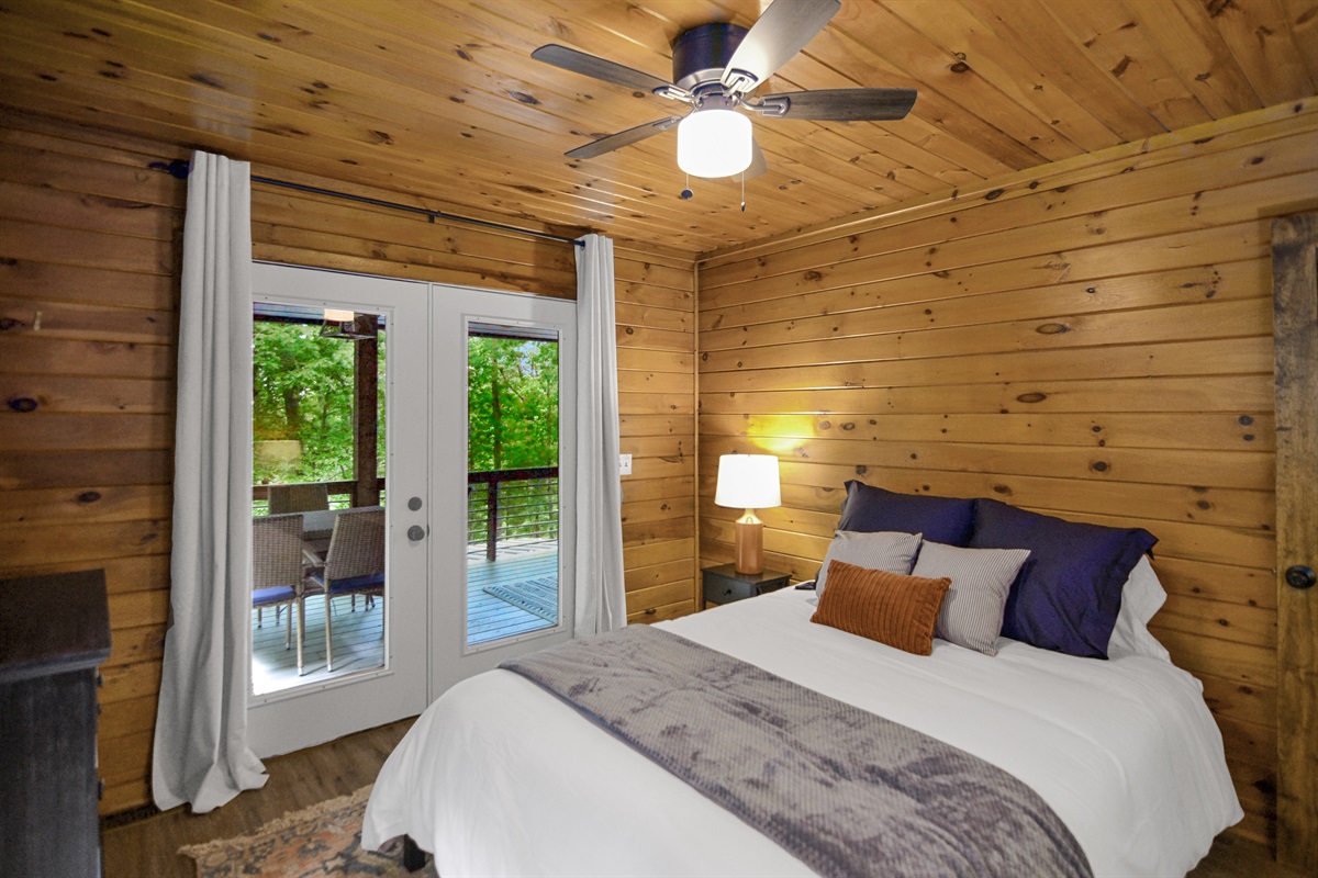 Bedroom on main level w/ double doors leading out to the front porch- queen bed 