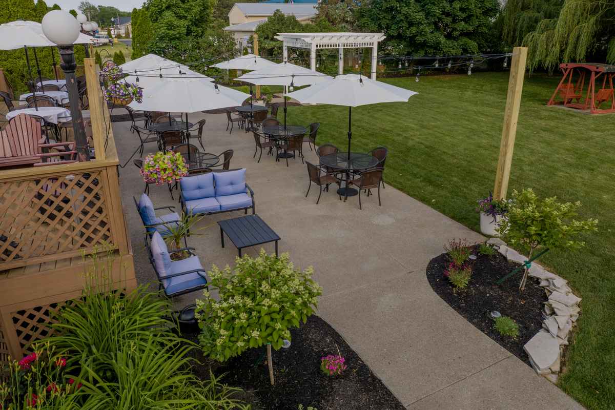 The Victorian Inn's grounds offer a relaxing retreat with flower gardens, shaded seating areas, a wedding pergola, romantic swing, and inviting outdoor gathering spaces