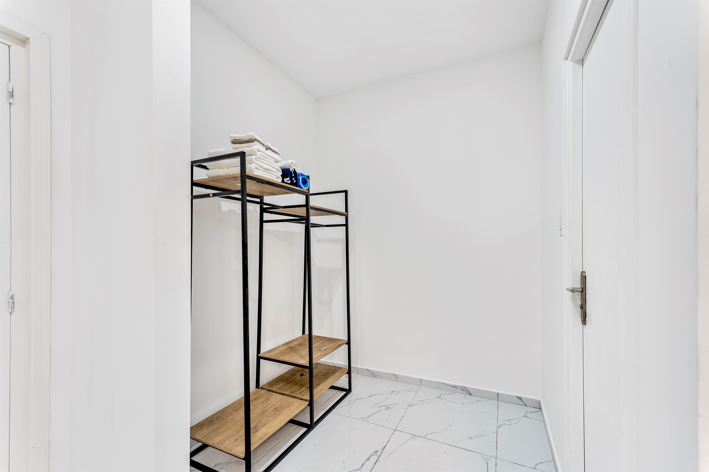 Hallway/closet space with open shelving and towels