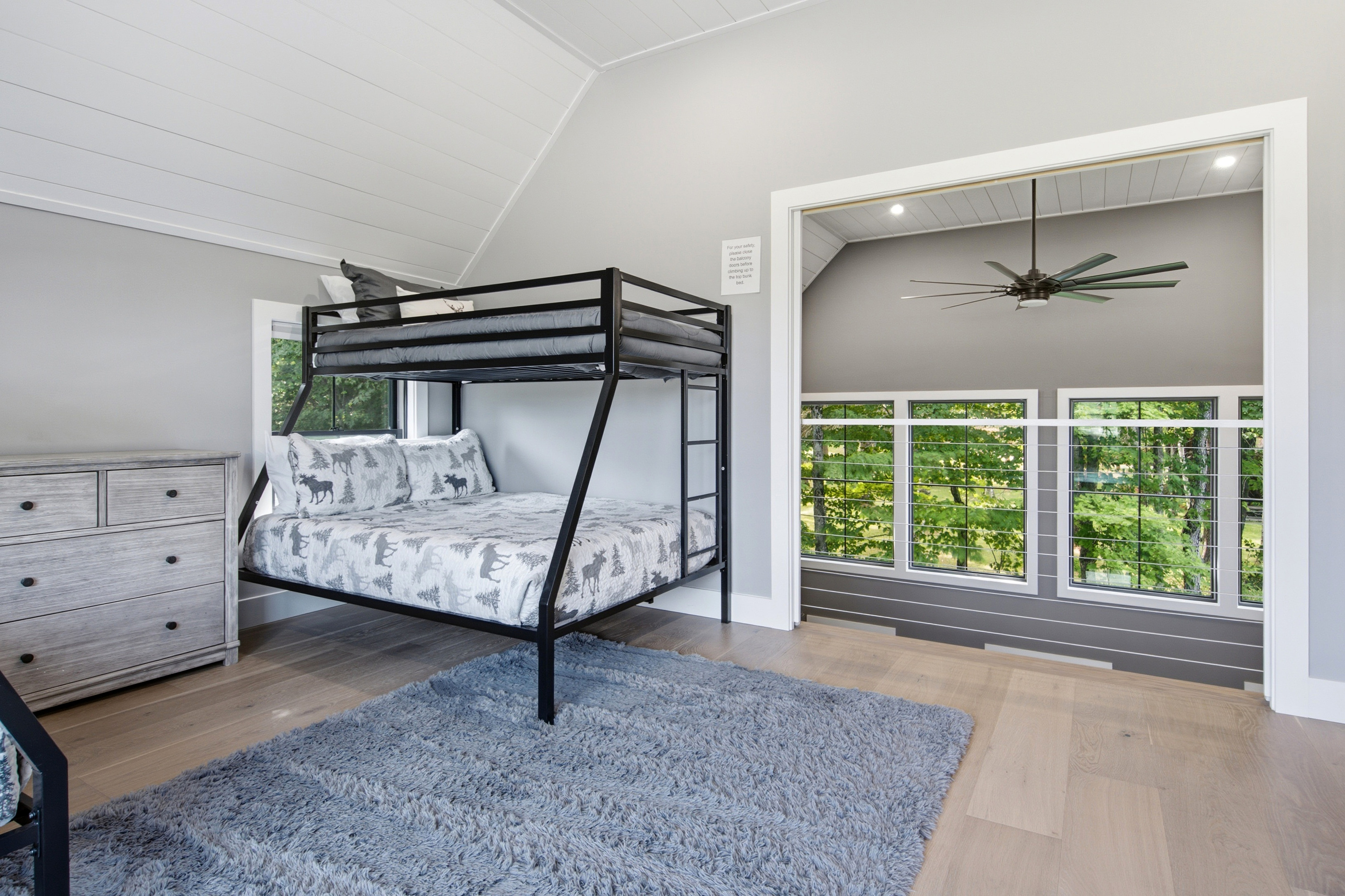 Bright windows and comfortable bunk beds create a welcoming retreat surrounded by natural scenery.