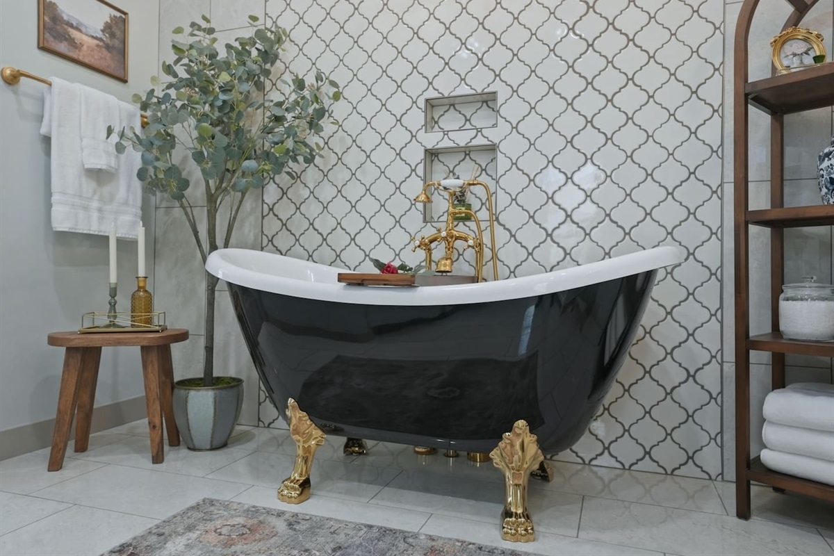 Elegant clawfoot soaking tub with gold accents, perfect for a relaxing spa-like retreat 