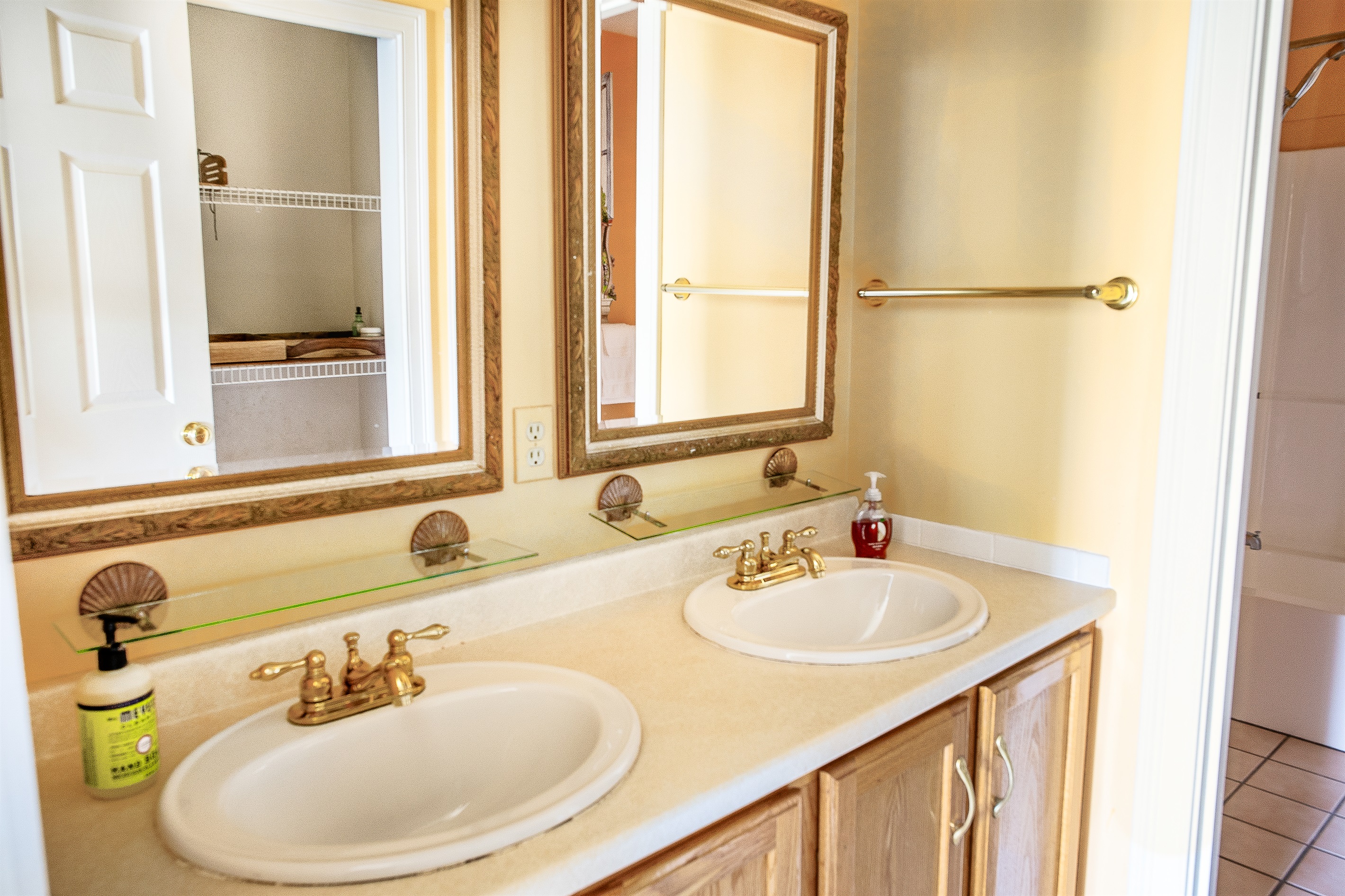 The primary en suite features a spacious dual vanity with elegant gold fixtures and ample counter space. It’s a bright, functional area that makes getting ready for a sunrise hike at Acadia National Park easy and efficient for two.