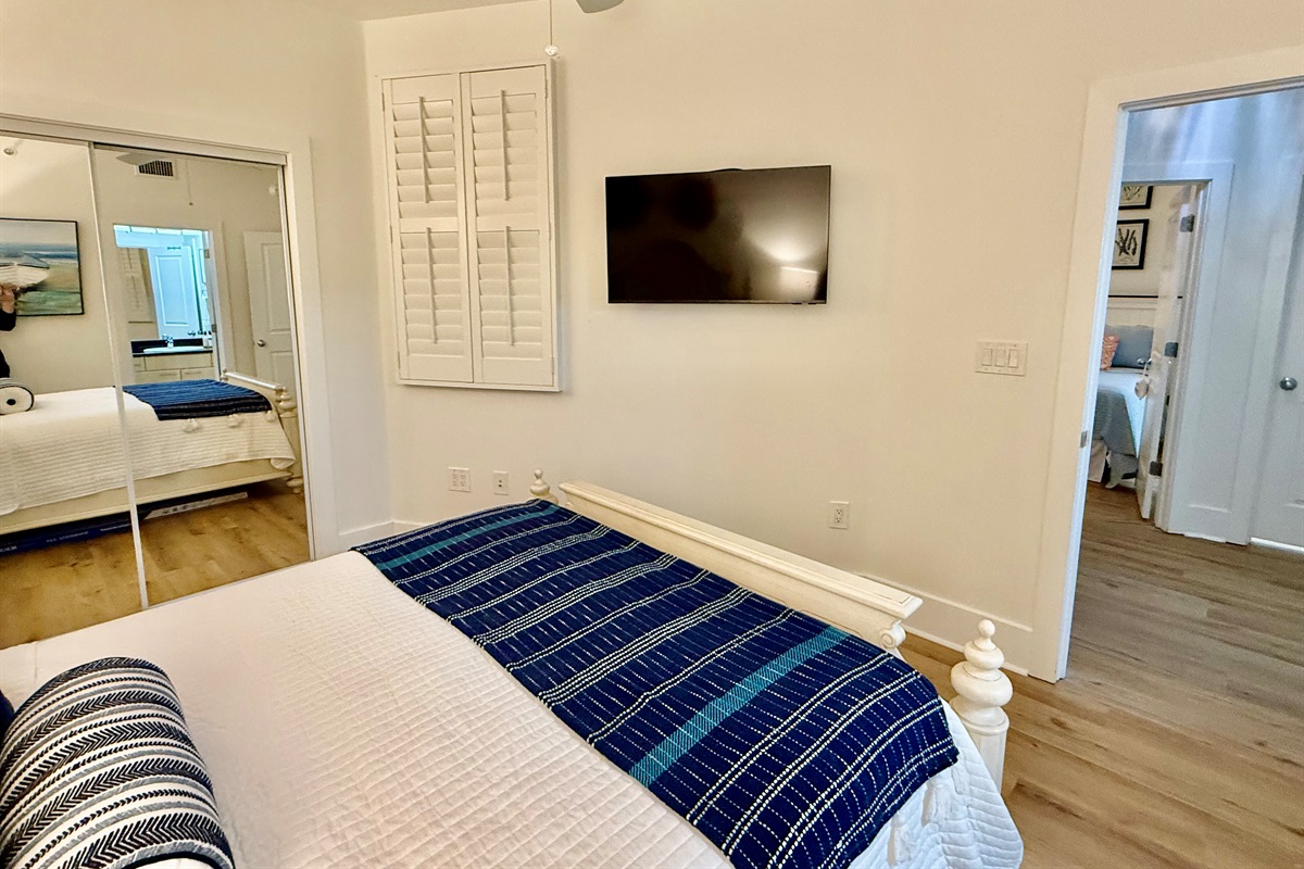 This bedroom also has lots of storage and a smart tv on the wall.