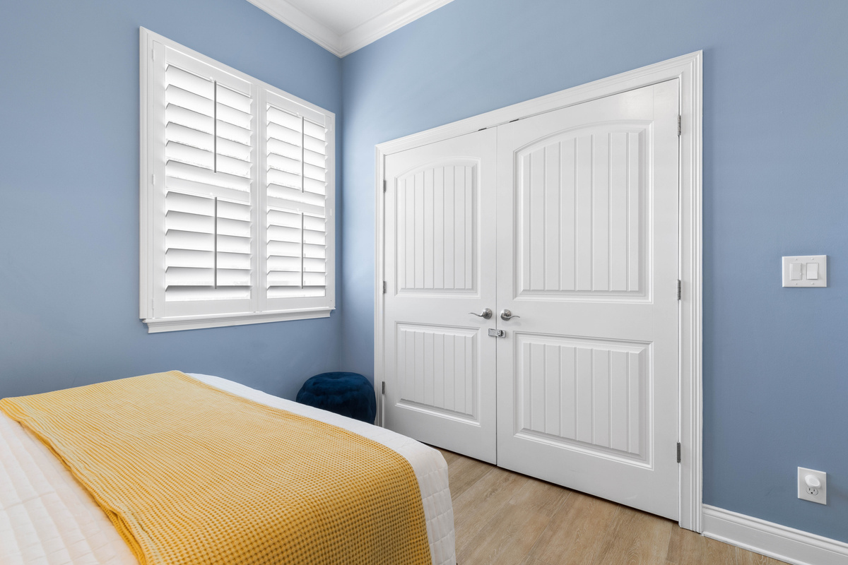 Double closet in the Periwinkle room holds bags and beach clothes, so the floor stays clear in a shared room.