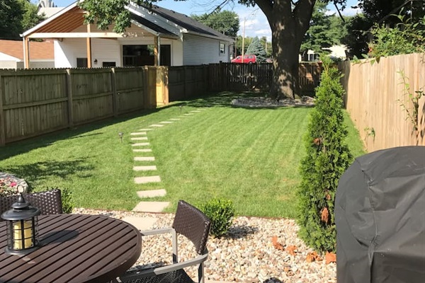 Large back yard with parking area beyond fence