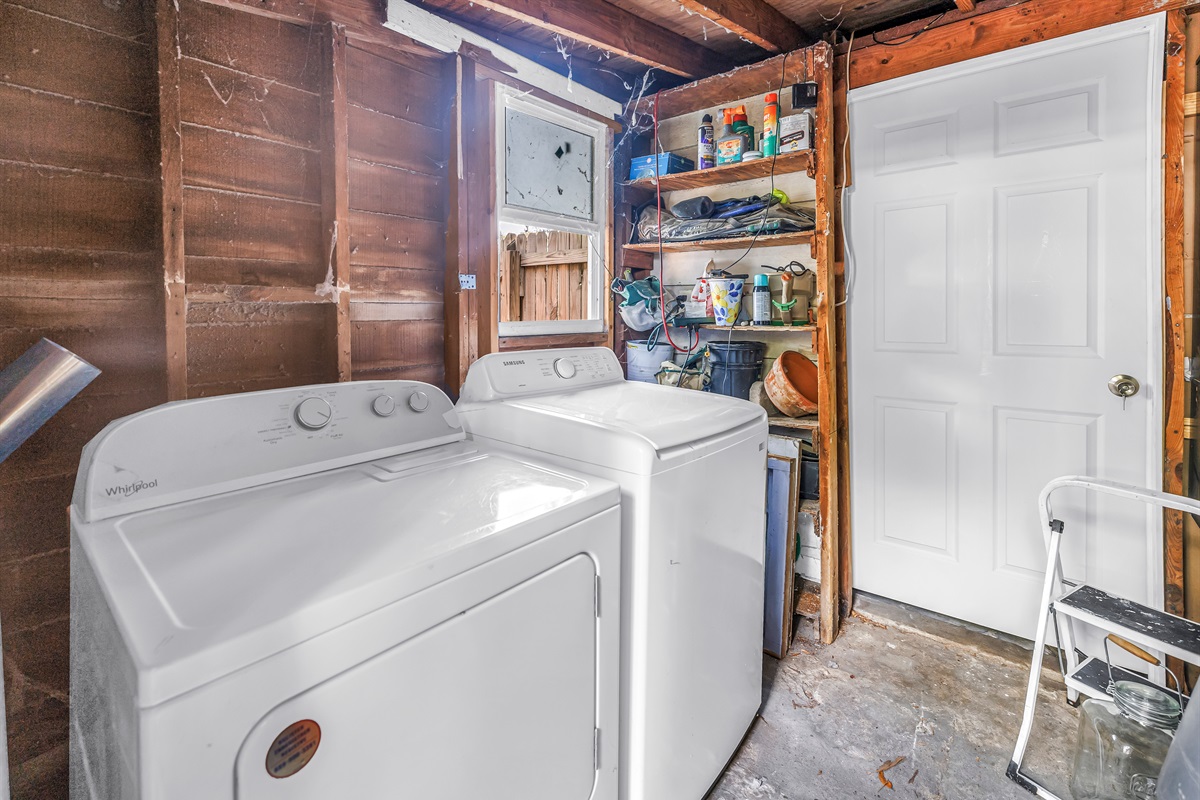 Laundry area with washer, dryer, utility shelving, and extra storage space for everyday convenience.
