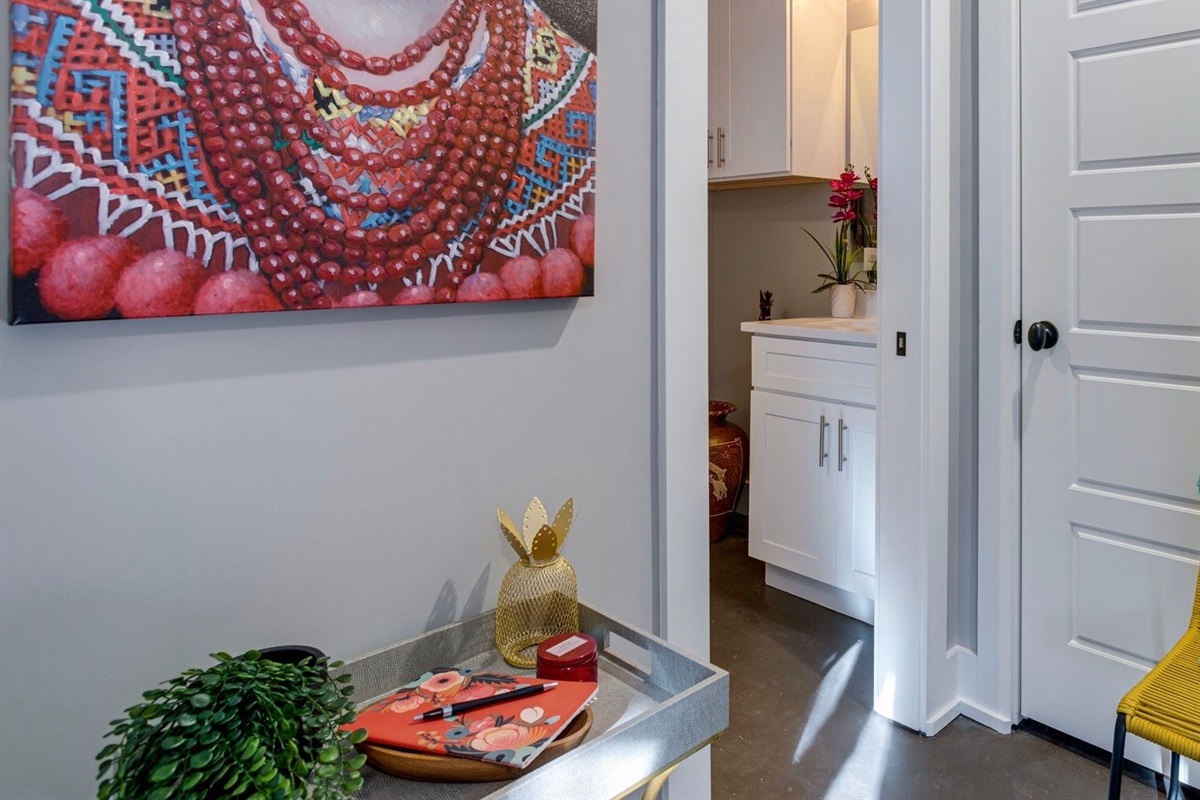 - Every corner has character, colorful art and playful touches greet you at every turn - Pineapple tray, greenery, and vibrant wall art set a fun, welcoming tone - Glimpse into the vanity area, styled for both comfort and convenience