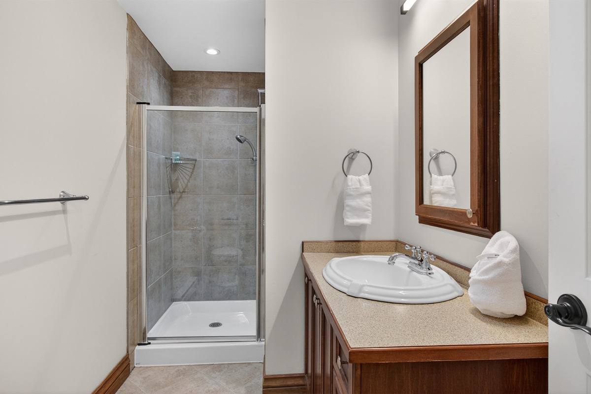 Upstairs bathroom w/ walk-in shower & warm finishes.