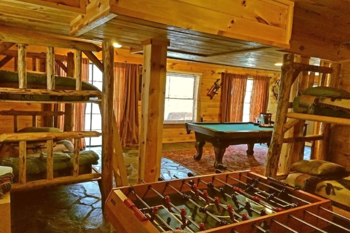 Large lower level game room with pool table and foos ball table, games two sets of log bunk beds, full bath, washer/ dryer and a table that seats four. Two sets of sliding glass doors open to the lower level deck , hot tub and back yard with stream.
